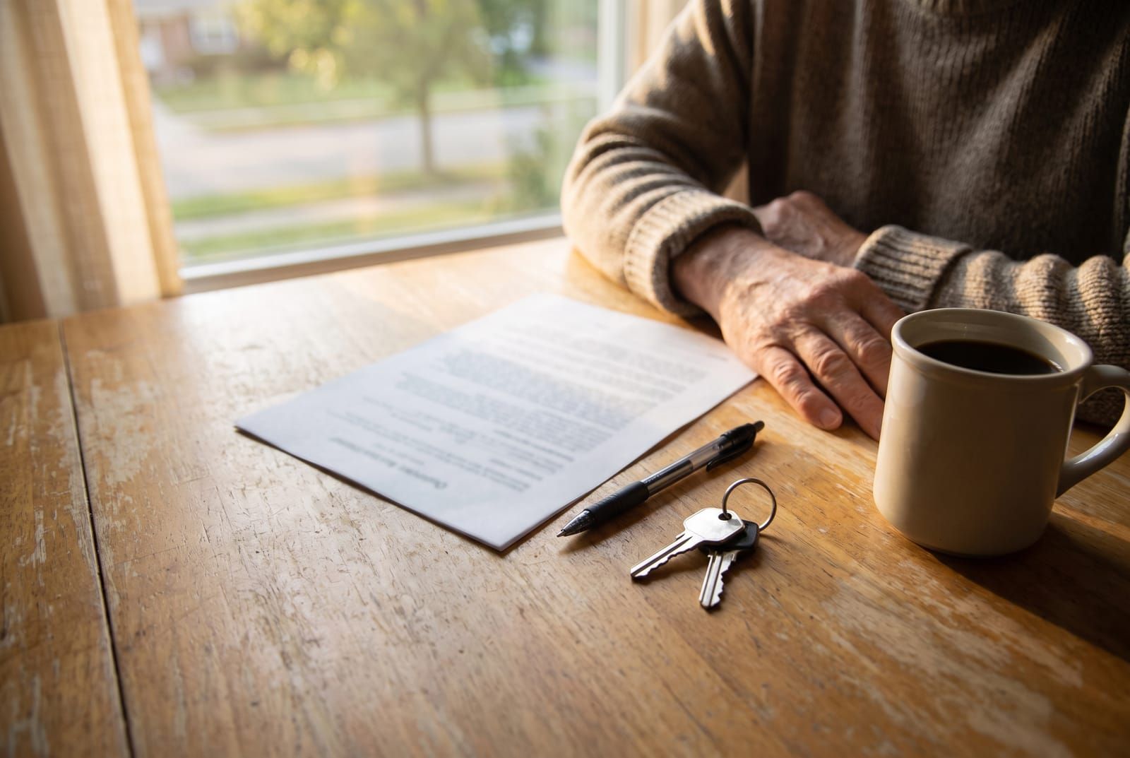 Paperwork, a pen and keys on a kitchen table