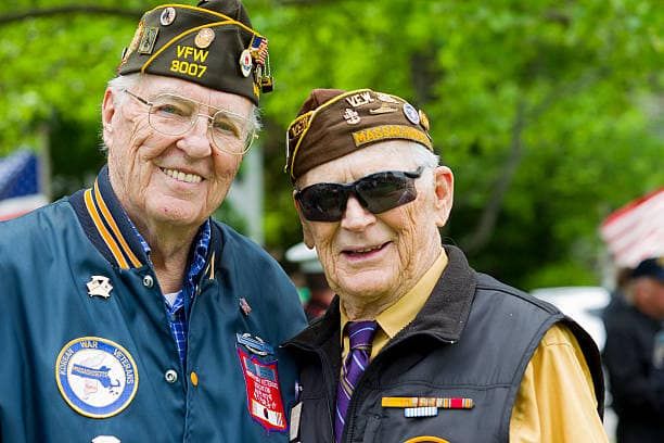 Two veterans in their service caps, smiling